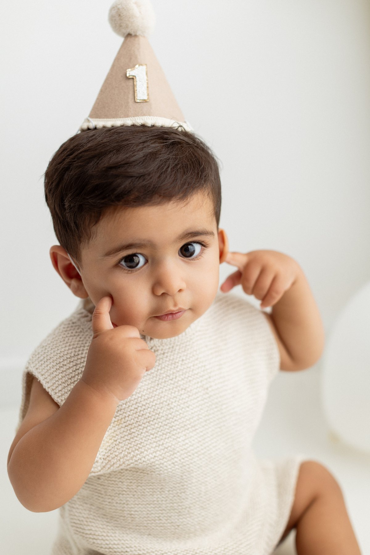 Close-up of a baby in a first birthday party hat