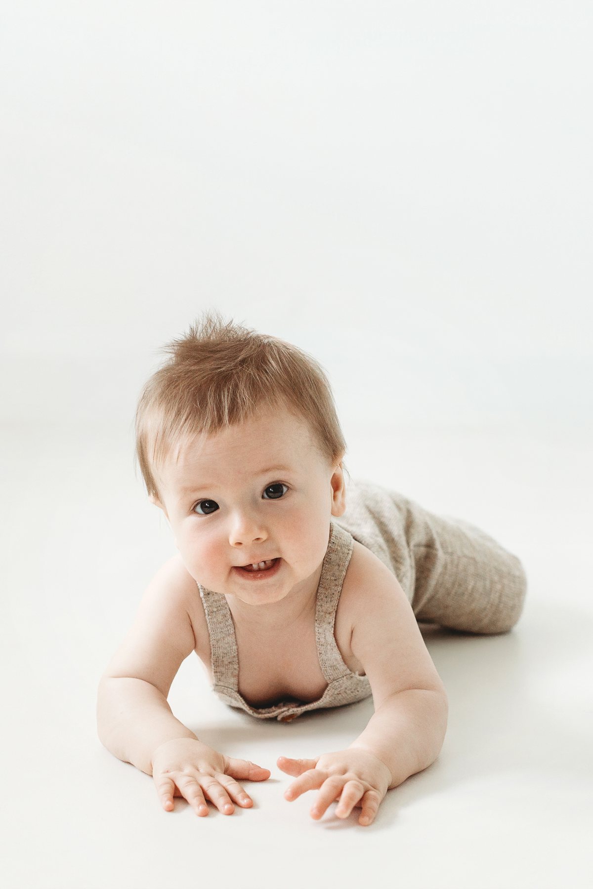 Smiling baby during tummy time at a milestone mini photoshoot